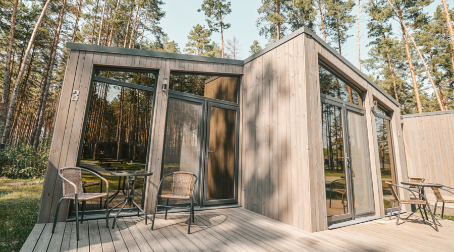 a wooden house with a table and chairs outside