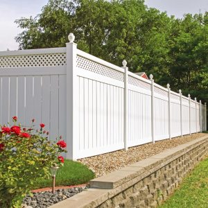 a white fence with red flowers and grass